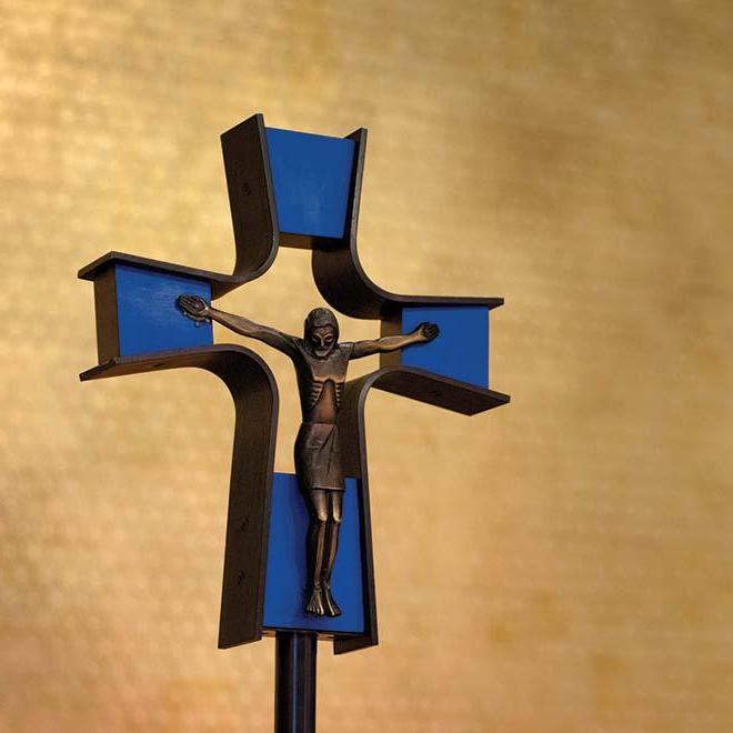 Closeup of crucifix in Our Lady of the Annunciation Chapel with a gold leaf wall in the background.