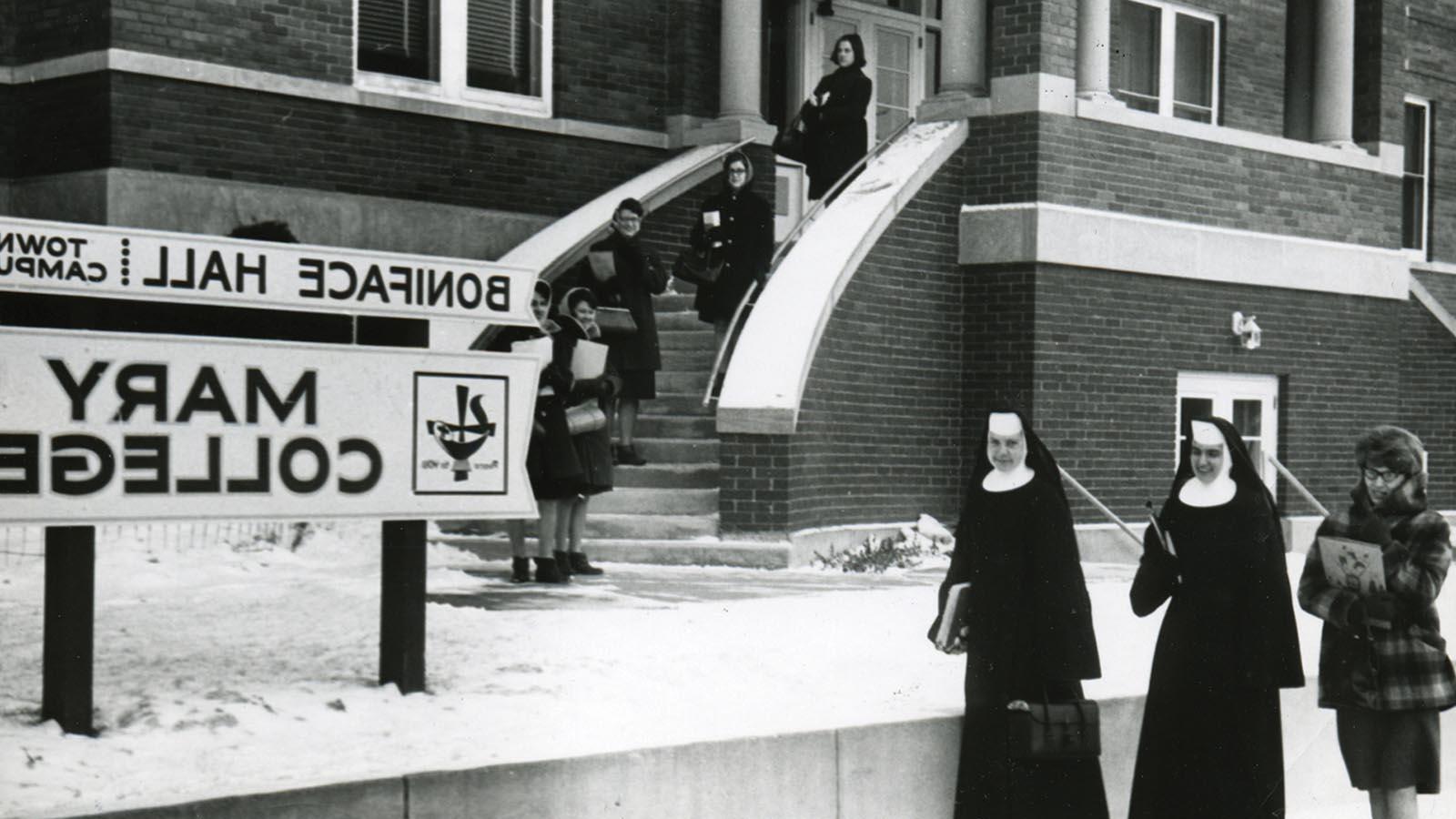 Historic image of Sisters and students standing outside Boniface Hall at the Mary College Town Campus